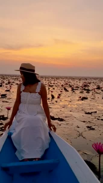 赤い蓮の海での日の出 ハーン湖 うどんタイ タイの赤い蓮の湖で日の出の間に木製のボートでアジアの女性 — ストック動画