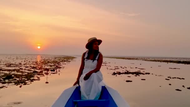 赤い蓮の海での日の出 ハーン湖 うどんタイ タイの赤い蓮の湖で日の出の間に木製のボートに帽子をかぶったアジアの女性 — ストック動画