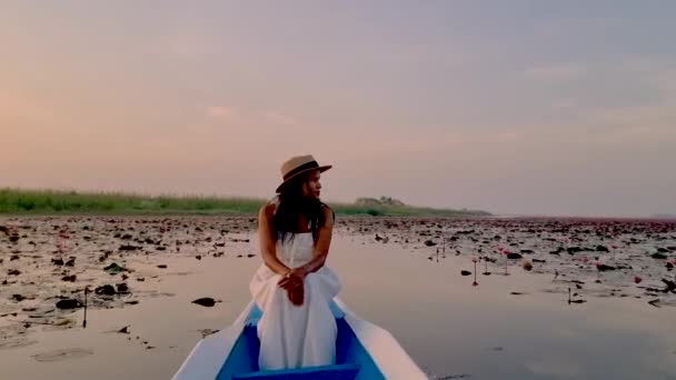 赤い蓮の海での日の出 ハーン湖 うどんタイ タイの赤い蓮の湖で日の出の間に木製のボートでアジアの女性 Isan地域 — ストック動画