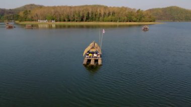Couple of men and women at a bamboo raft at Huai Krathing lake in North Eastern Thailand Isaan region