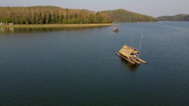 Couple of men and women at a bamboo raft at Huai Krathing lake in North Eastern Thailand Isaan region