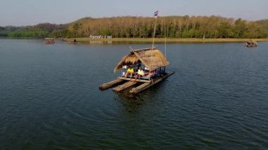 Couple of men and women at a bamboo raft at Huai Krathing lake in North Eastern Thailand Isaan region