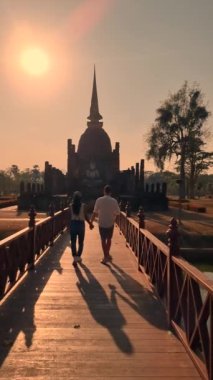 A couple of men and women visit historical city of Sukhothai old city, Thailand. Ancient city and culture of south Asia Thailand