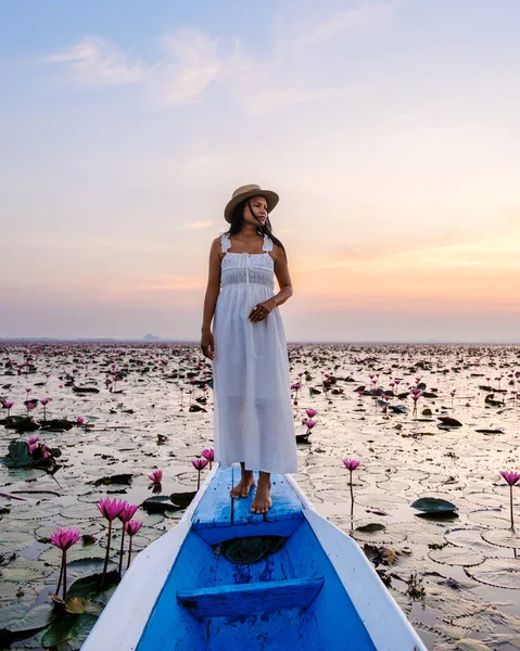 Asian women in a boat at the Beautiful Red Lotus Sea in Udon Thani in northern Thailand. Flora of Southeast Asia.