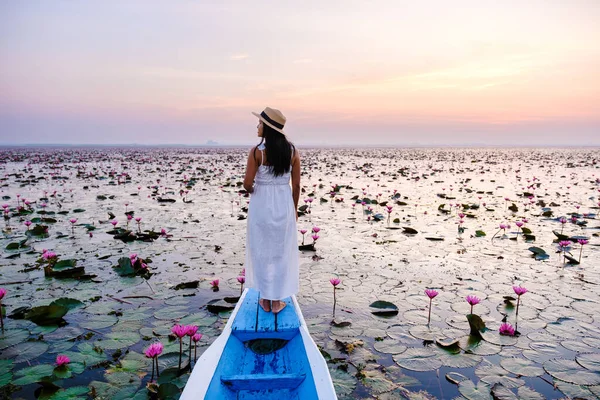 Asian women in a boat at the Beautiful Red Lotus Sea in Udon Thani in northern Thailand. Flora of Southeast Asia.