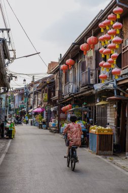 Chiang Khan Köyü Kuzey Doğu Tayland Şubat 2023, Mekong nehri kıyısında bisiklet süren insanlar. Ahşap evi olan geleneksel bir köy Chiang Khan