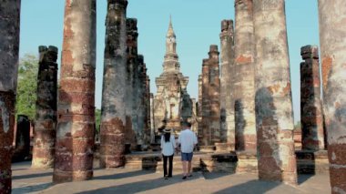 A couple of men and women visit Wat Mahathat, Sukhothai old city, Thailand. Ancient city and culture of south Asia Thailand