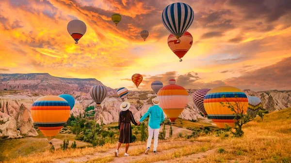 カッパドキアトルコ日の出の間に カッパドキアトルコの丘で休暇中のカップルの中年男性と女性 男性と女性カッパドキアトルコの熱気球で日の出を見る — ストック写真