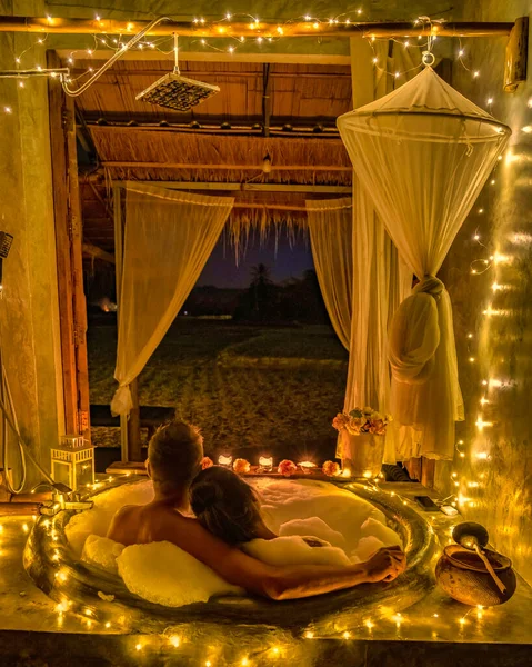 ホームステイ先の南タイの田舎にクリスマスライトのある浴槽に男女2人 — ストック写真