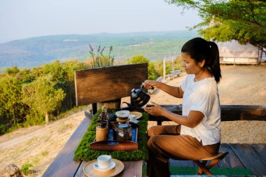 Tayland dağlarında damlayan kahve yapan kadınlar. Çadırda kahve hazırlayan Asyalı kadın.