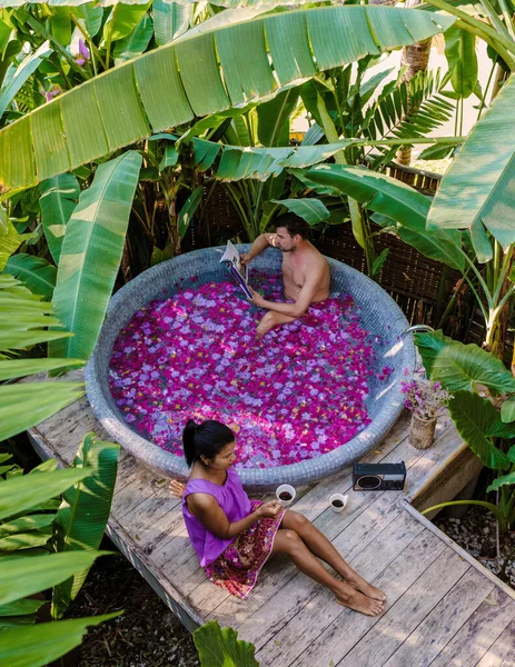 태국의 우림에 욕조에서 목욕하면서 휴식을 취하는 남녀들은 자연적으로 꽃잎이 휴식을 — 스톡 사진