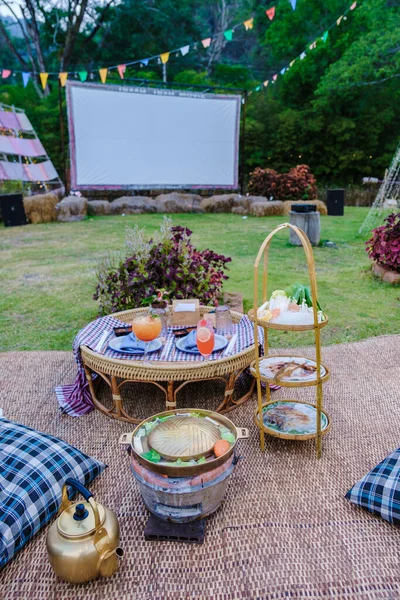 outdoor cinema film in a tropical garden with Christmas lights. H