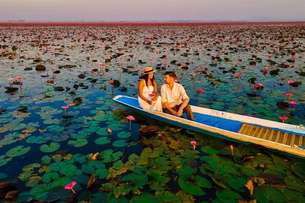 美しい紅蓮の海での木製ボートのカップルクンパワピはタイ北部のウドタニにピンクの花がたくさんあります 東南アジアの植物 — ストック写真