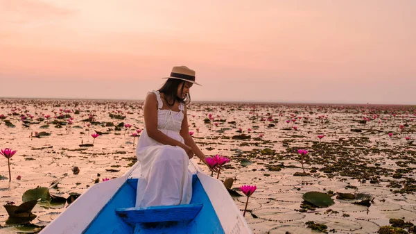 赤い蓮の海でタイの女性 ハーン湖 うどんタニー 赤い蓮の湖で木製のボートでドレスや帽子を持つアジアの女性 — ストック写真