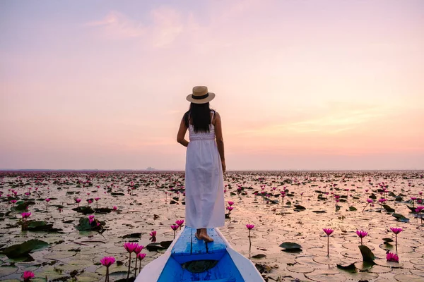 赤い蓮の海でタイの女性 ハーン湖 うどんタニー 赤い蓮の湖で木製のボートでドレスや帽子を持つアジアの女性 — ストック写真