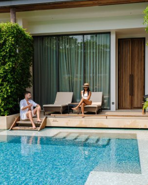 Asya 'da lüks 5 yıldızlı otel havuzu. Lüks bir otelde tatil yapan birkaç erkek ve kadın, havuz başında beyaz erkekler ve Taylandlı kadınlar.