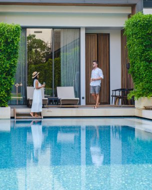 Asya 'da lüks 5 yıldızlı otel havuzu. Lüks bir otelde tatil yapan bir çift erkek ve kadın, akşamları havuz başında erkekler ve kadınlar.