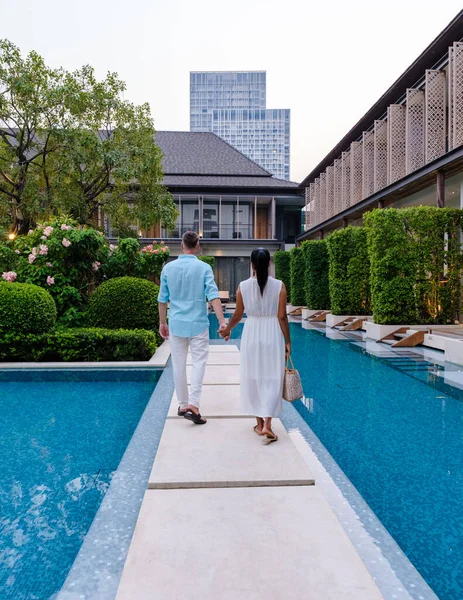 Luxury 5 star hotel pool in Asia. A couple of men and women on vacation at a luxury hotel resort, men and women by the pool of a resort