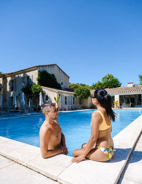 couple relaxing by the swimmingpool in the Provence France, men, and woman relaxing by the pool at a luxury resort in France.