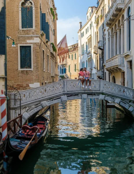 在意大利威尼斯的城市旅行中 一对男女情侣坐在一座桥旁 位于意大利威尼斯 威尼斯的建筑和地标 威尼斯夏季的城市景观 — 图库照片