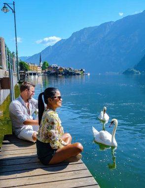 Avusturya, Salzkammergut, Avusturya 'da, Avusturya Alpleri' ndeki Hallstatt Gölü 'ndeki Hallstatt köyünde gün batımında Avusturya' da tatil yapan birkaç erkek ve kadın.. 