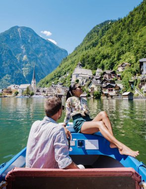 Avusturya, Salzkammergut, Avusturya 'da, Avusturya Alpleri' ndeki Hallstatt Gölü 'ndeki Hallstatt köyünde gün batımında Avusturya' da tatil yapan birkaç erkek ve kadın.. 