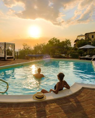 İtalya 'da yüzme havuzu olan lüks bir kır evi. Orta İtalya 'da günbatımında havuz ve eski çiftlik evi. İtalya 'da lüks bir villada tatil yapan çift, gün batımını izleyen erkek ve kadın.. 