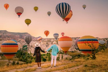 Gündoğumunda Kapadokya Türkiye, Goreme Capadocia Türkiye tepelerinde tatil yapan iki orta yaşlı erkek ve kadın, Kapadokya Türkiye 'de sıcak hava balonlarıyla güneşlenen erkekler ve kadınlar