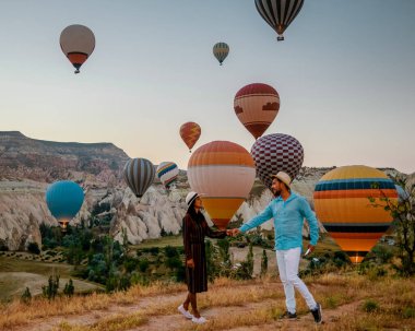 Gündoğumunda Kapadokya Türkiye, Goreme Capadocia Türkiye tepelerinde tatil yapan iki orta yaşlı erkek ve kadın, Kapadokya Türkiye 'de sıcak hava balonlarıyla güneşlenen erkekler ve kadınlar