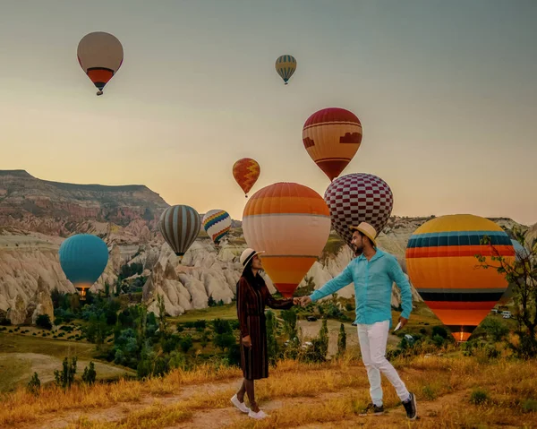 カッパドキアトルコ日の出の間に カッパドキアトルコの丘で休暇中のカップルの中年の男性と女性 男性と女性はカッパドキアトルコの熱気球で日の出を見て — ストック写真