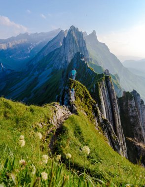 Schaeffler dağ sırtı İsviçreli Alpstein, Appenzell İsviçre, Berggasthaus Schafler, İsviçre 'nin görkemli Schaeffler zirvesinin bir sırtı. Gün batımında dağlarda bir çift erkek ve kadın.