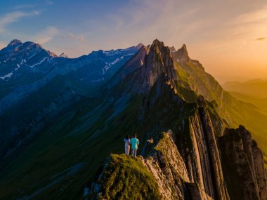 Schaeffler dağ sırtı İsviçreli Alpstein, Appenzell İsviçre, Berggasthaus Schafler, İsviçre 'nin Schaeffler zirvesinin bir sırtı. Gün batımında dağlarda bir çift erkek ve kadın.