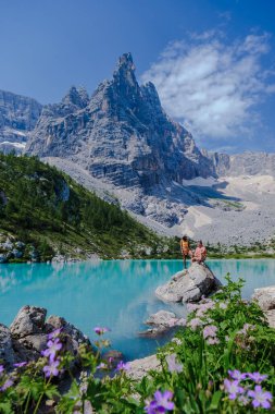 İtalyan Dolomitleri 'nde Lago di Sorapis' i, süt mavisi Lago di Sorapis gölünü, Sorapis Gölü 'nü, Dolomitleri, İtalya' yı ziyaret eden iki erkek ve kadın..