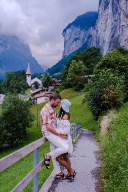 Lauterbrunnen Vadisi 'nde muhteşem bir şelale ve arka planda İsviçre Alpleri olan Berner Oberland, İsviçre ve Avrupa' yı ziyaret eden iki erkek ve kadın.. 