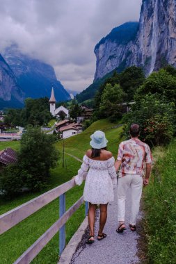 Arka planda muhteşem bir şelale ve İsviçre Alpleri olan Lauterbrunnen Vadisi 'ni ziyaret eden çift, Berner Oberland, İsviçre, Avrupa. 