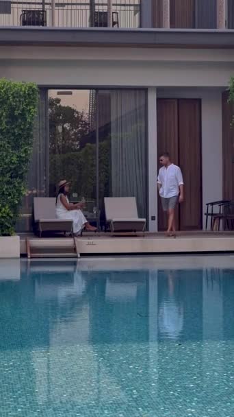 アジアの高級5つ星ホテルプール プール付きの高級ホテルリゾートで休暇中の男性と女性のカップル — ストック動画