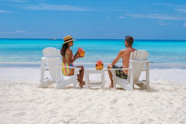 Sahilde hindistan cevizli birkaç kadın ve erkek Praslin Seyşeller içiyorlar. Beyaz plajları ve palmiye ağaçları olan tropik bir ada. Anse Volbert Seyşeller plajı..