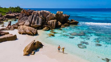 Anse Cocos La Digue Seyşeller, Seyşeller 'de lüks bir tatil sırasında tropik bir plajda yaşayan genç bir çift. Tropik sahil Anse Cocos La Digue Seyşeller.