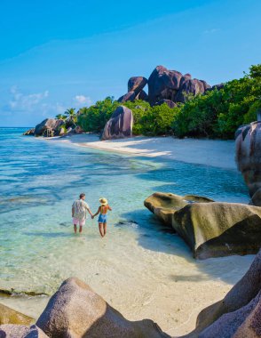 Anse Source dArgent, La Digue Seychelles, Seyşeller 'de lüks bir tatil sırasında tropik bir plajda iki genç erkek ve kadın..