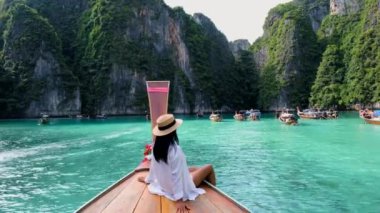 Koh Phi Phi Tayland gölünde, uzun kuyruklu bir teknenin önündeki kadın. Tayland 'da Tayland' lı Pileh Lagoon Tayland 'lı kadınların önünde. 