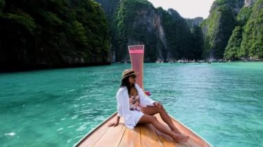 Koh Phi Phi Tayland gölünde, uzun kuyruklu bir teknenin önündeki kadın. Tayland 'da Tayland' lı Pileh Lagoon Tayland 'lı kadınların önünde. 