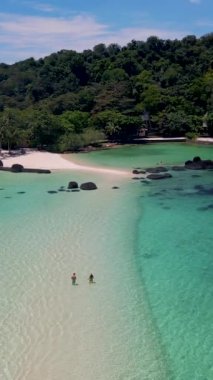 Koh Chang bölgesindeki Koh Mak yakınlarındaki Koh Kham Adası 'nın kumsalında bir çift. Tayland' da beyaz plajı ve turkuaz renkli okyanusu olan tropikal bir ada..
