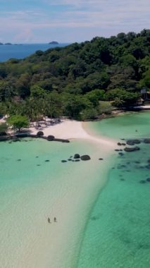 Koh Chang bölgesindeki Koh Mak yakınlarındaki Koh Kham Adası 'ndaki bir kumsalda bir çift kadın ve erkek. Tayland' da beyaz plajı ve turkuaz renkli okyanusu olan tropikal bir ada..