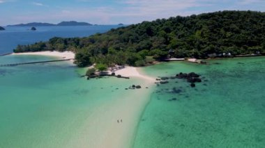Koh Chang bölgesindeki Koh Mak yakınlarındaki Koh Kham Adası 'ndaki bir kumsalda bir çift kadın ve erkek. Tayland' da beyaz plajı ve turkuaz renkli okyanusu olan tropikal bir ada..