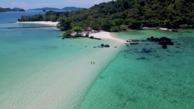 Koh Chang bölgesindeki Koh Mak yakınlarındaki Koh Kham Adası 'nın kumsalında bir çift. Tayland' da beyaz plajı ve turkuaz renkli okyanusu olan tropikal bir ada..