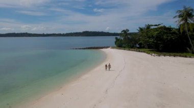 Koh Chang bölgesinde Koh Mak yakınlarındaki tropikal beyaz kumsaldaki Koh Kham Adası 'nda beyaz plajı ve Tayland' da turkuaz renkli okyanusu olan bir çift..