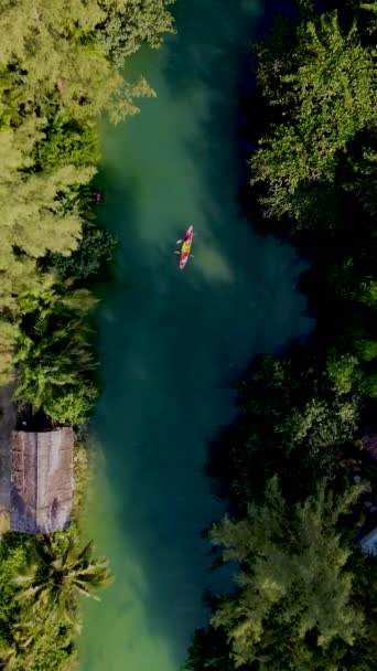 两名男子和女子乘坐皮划艇在热带岛屿上的Koh Chang Thailand 日落时分在热带雨林Koh Chang的一条热带河流上的皮划艇上看到无人驾驶飞机 — 图库视频影像