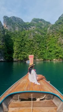 Pileh Lagoon Koh Phi Phi Maya Körfezi Tayland 'da uzun kuyruklu bir teknenin önündeki Asyalı kadınlar Koh Phi Phi Maya Körfezi gezisi sırasında