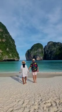 Koh Phi Maya Körfezi Tayland, Koh Phi Phi Adası 'na tekne gezisi sırasında turkuaz renkli okyanusta yürüyen bir çift orta yaşlı erkek ve kadın.