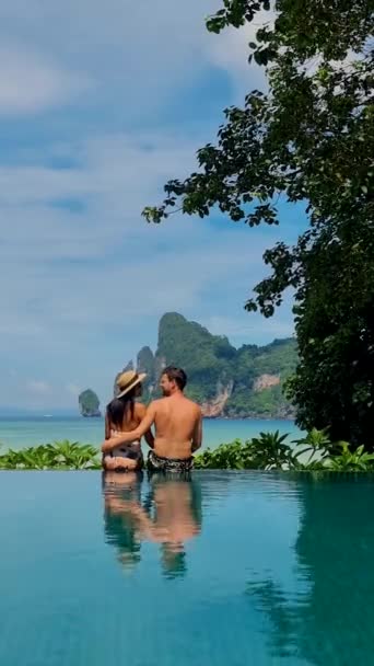一对夫妇的男人和女人在一个无限大的游泳池里俯瞰着泰国海滩 在泰国度假的中年夫妇在游泳池边放松一下 — 图库视频影像